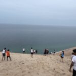 Athletes hem and haw over whether or not to go down the steep dune.